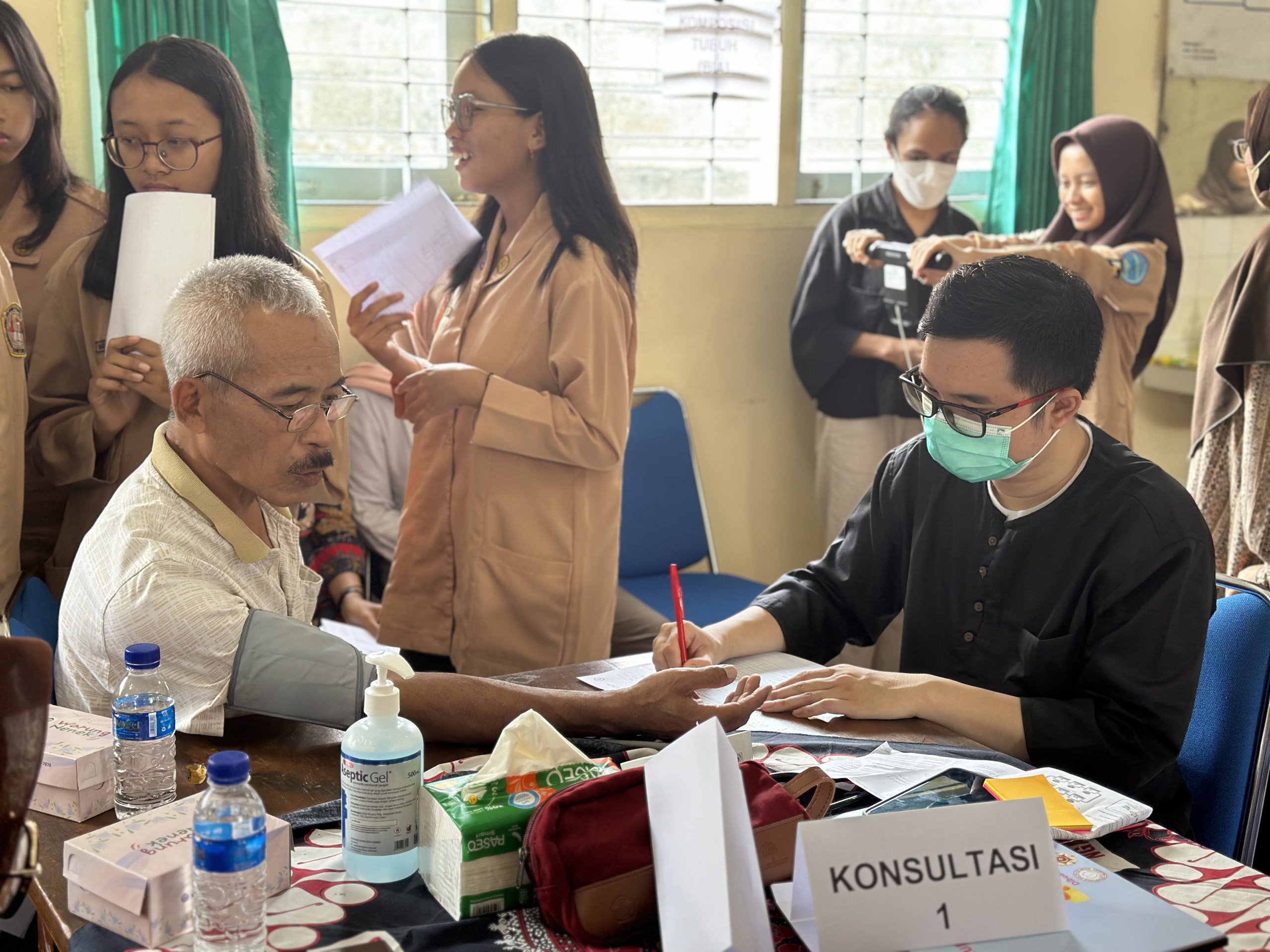 Pengukuran tekanan darah dan konsultasi dengan mahasiswa MIB Minat Biokimia FK-KMK UGM, dr. Ihsan.